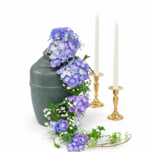 Urndekoration med blå och lila blommor samt grönt